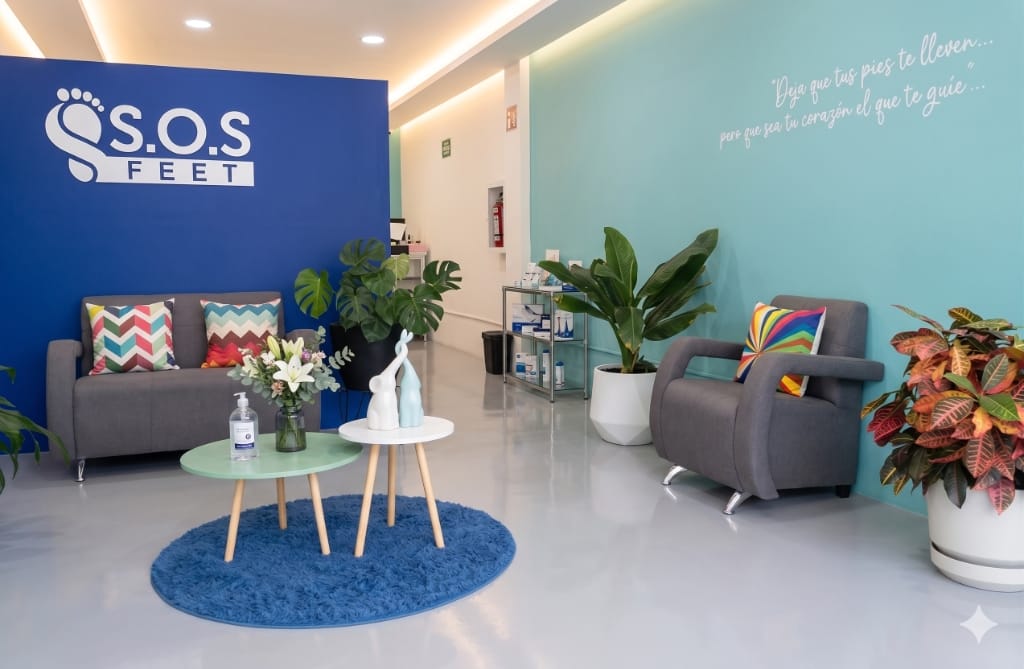 Recepción de la clínica S.O.S Feet con sala de espera y el logotipo en la pared